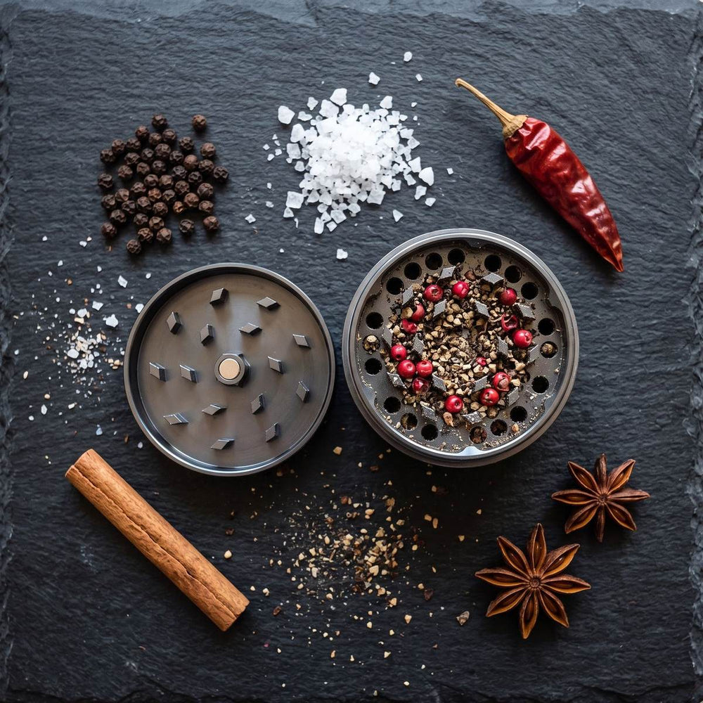 Geöffnete Gewürzmühle mit Pfeffer, Salz und Chili